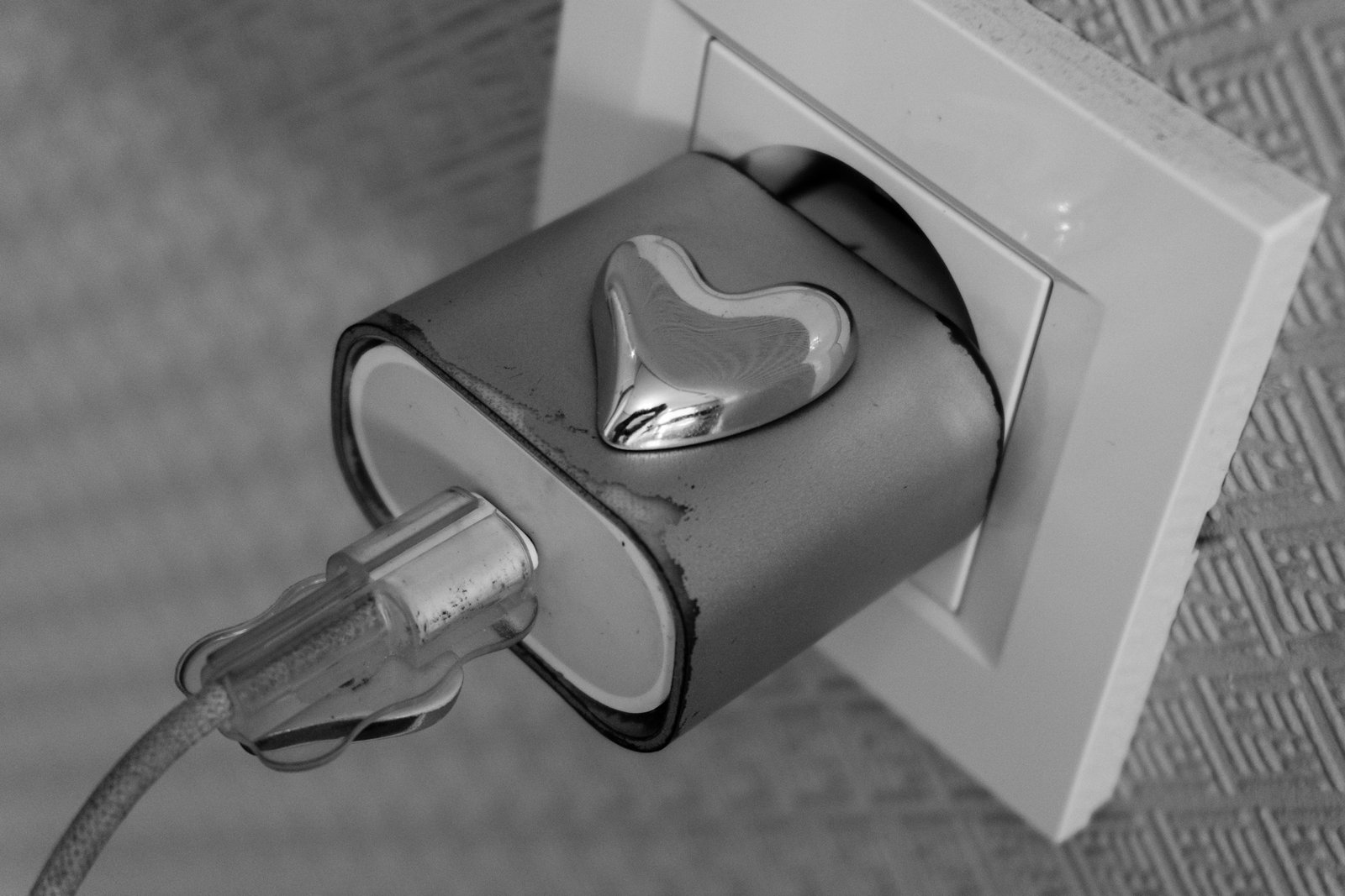 Hand zieht einen Stecker aus einer leicht gelockerten Steckdose