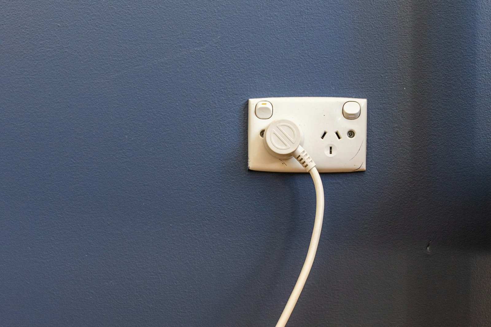 Steckdose mit eingestecktem Stecker, bei der der Bereich um die Kontakte leicht verfärbt wirkt