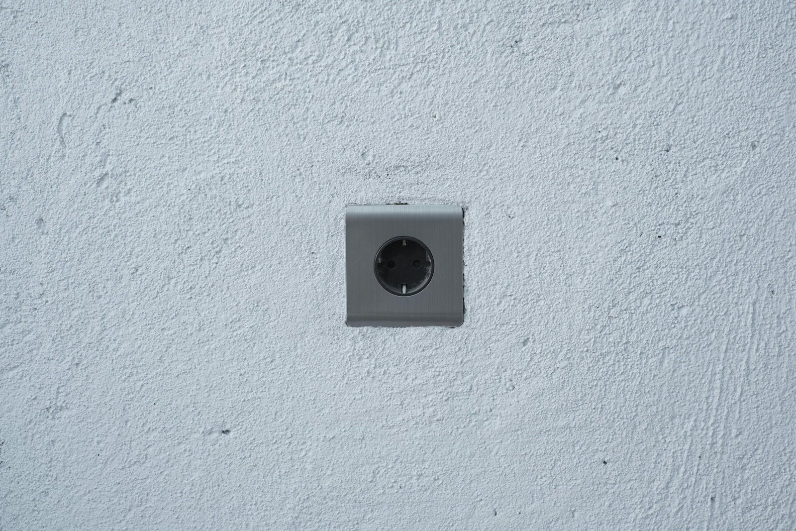 Geöffnete Unterputz-Steckdose mit sichtbaren seitlichen Befestigungskrallen